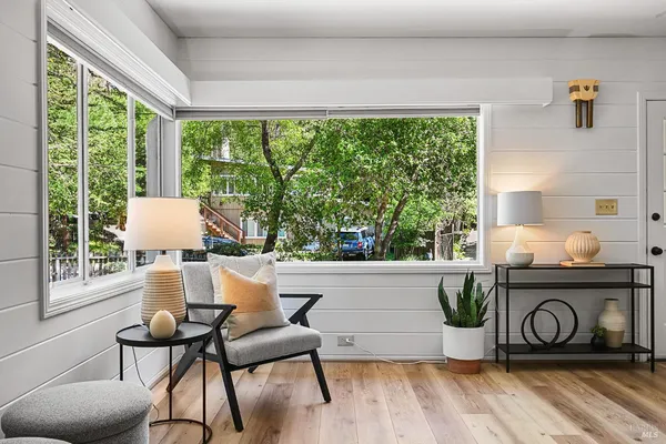 a view of a hallway with wooden floor and a potted plant