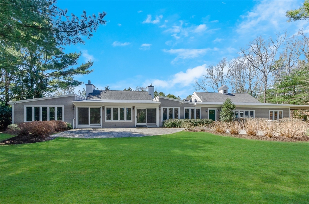 345 Point Road Marion, MA 02738 - Photo 1 of 41 a front view of a house with a garden and trees