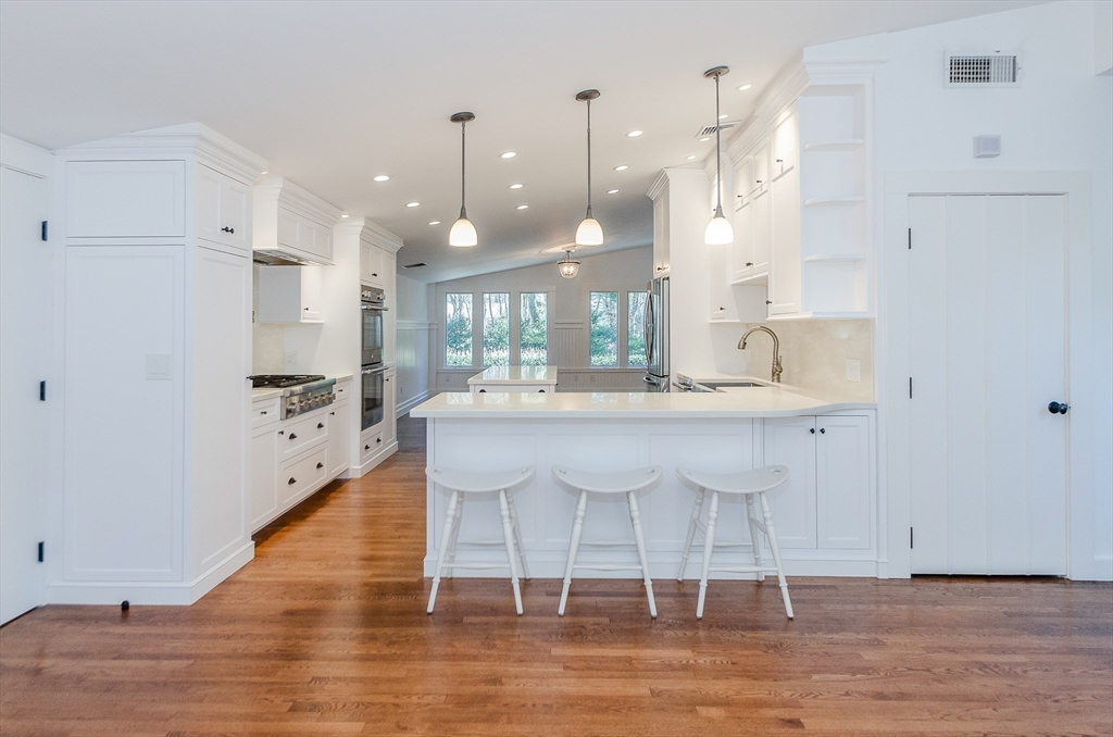 345 Point Road Marion, MA 02738 - Photo 11 of 41 a kitchen with kitchen island stainless steel appliances a dining table chairs sink and cabinets
