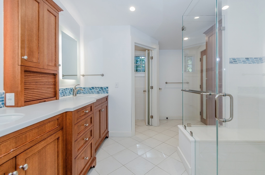 345 Point Road Marion, MA 02738 - Photo 22 of 41 a bathroom with a granite countertop sink a mirror and shower