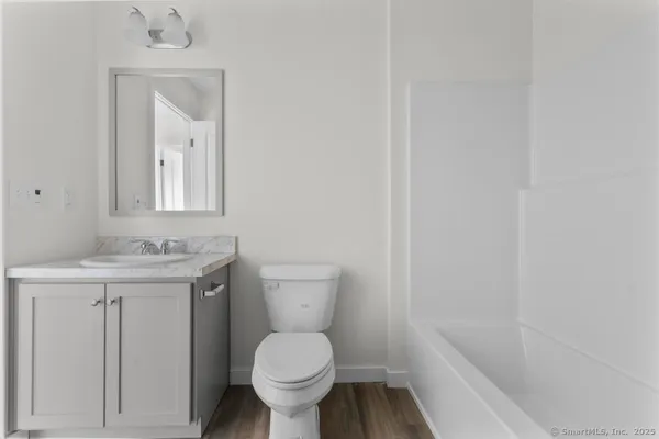 a bathroom with a toilet a sink and mirror