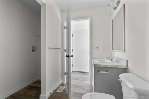 a bathroom with a granite countertop toilet sink and a mirror