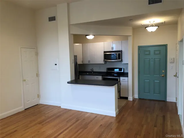 a kitchen with granite countertop a refrigerator and a stove top oven