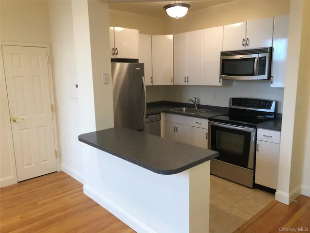 a kitchen with stainless steel appliances granite countertop a stove a refrigerator and a microwave