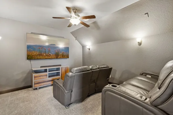 a living room with furniture and a ceiling fan