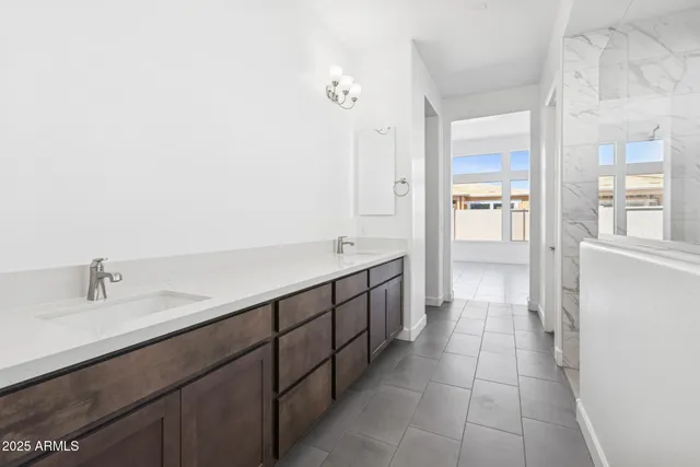a spacious bathroom with a double vanity sink a mirror and a shower