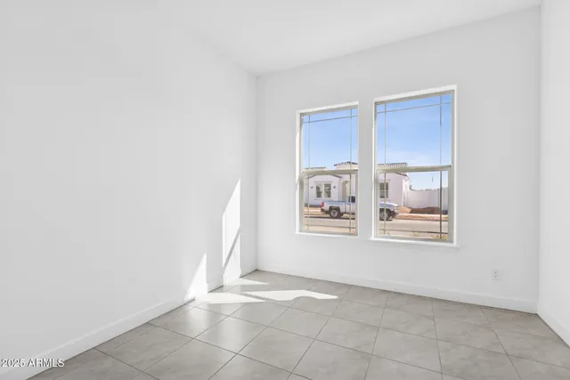 a view of an empty room with closet and a window