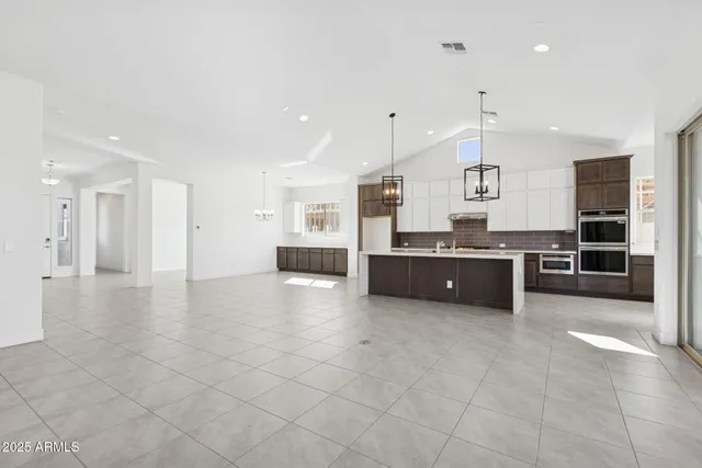 a large kitchen with stainless steel appliances a large counter top a stove and a refrigerator