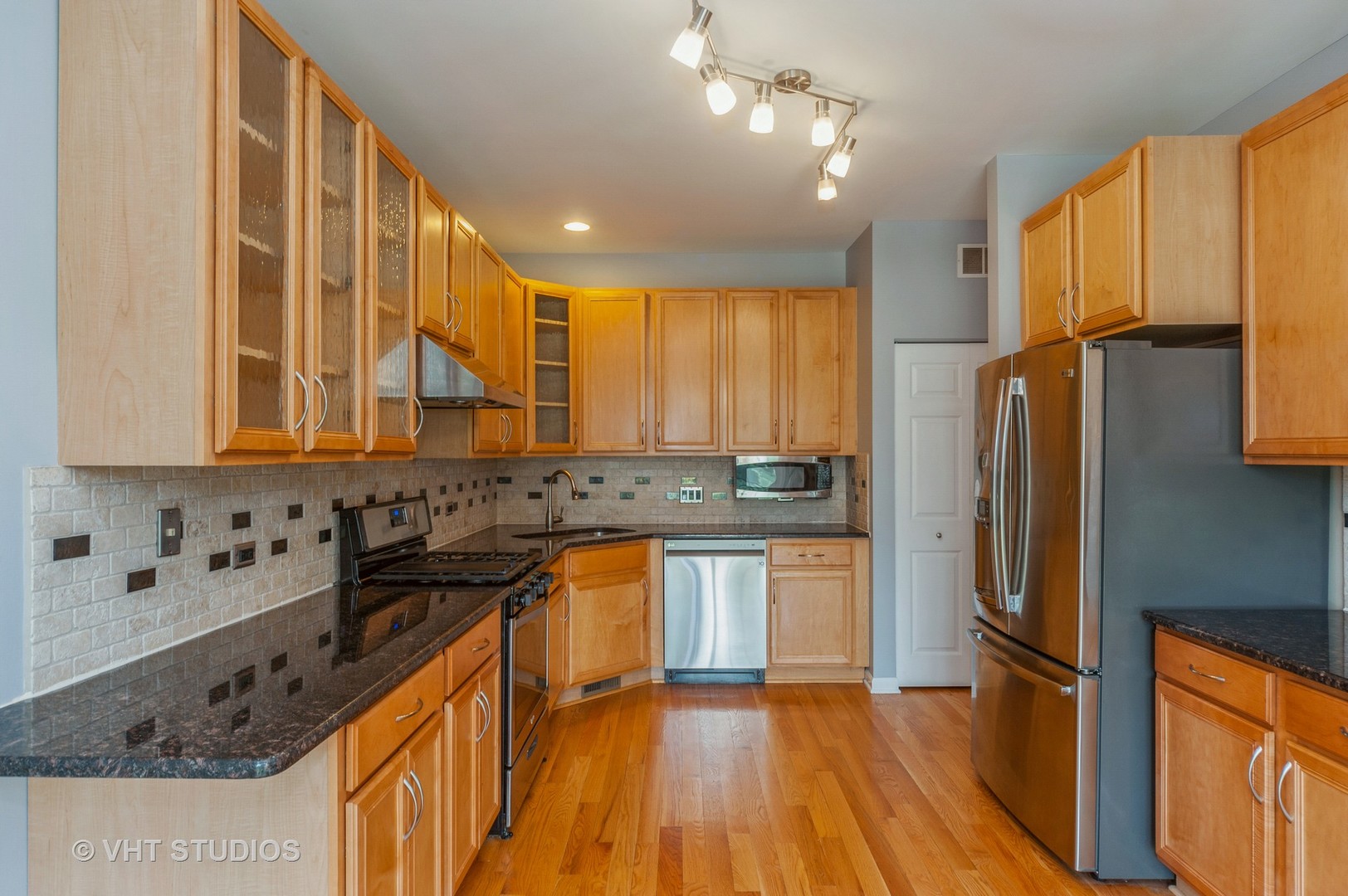 360 Bay Tree Circle Vernon Hills, IL 60061 - Photo 8 of 18 a kitchen with stainless steel appliances granite countertop a refrigerator a sink dishwasher a stove and white countertops with wooden floor