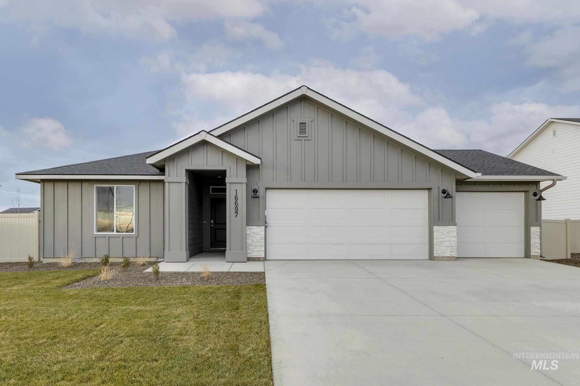 Single story home featuring board and batten siding, a shingled roof, a garage, and concrete driveway