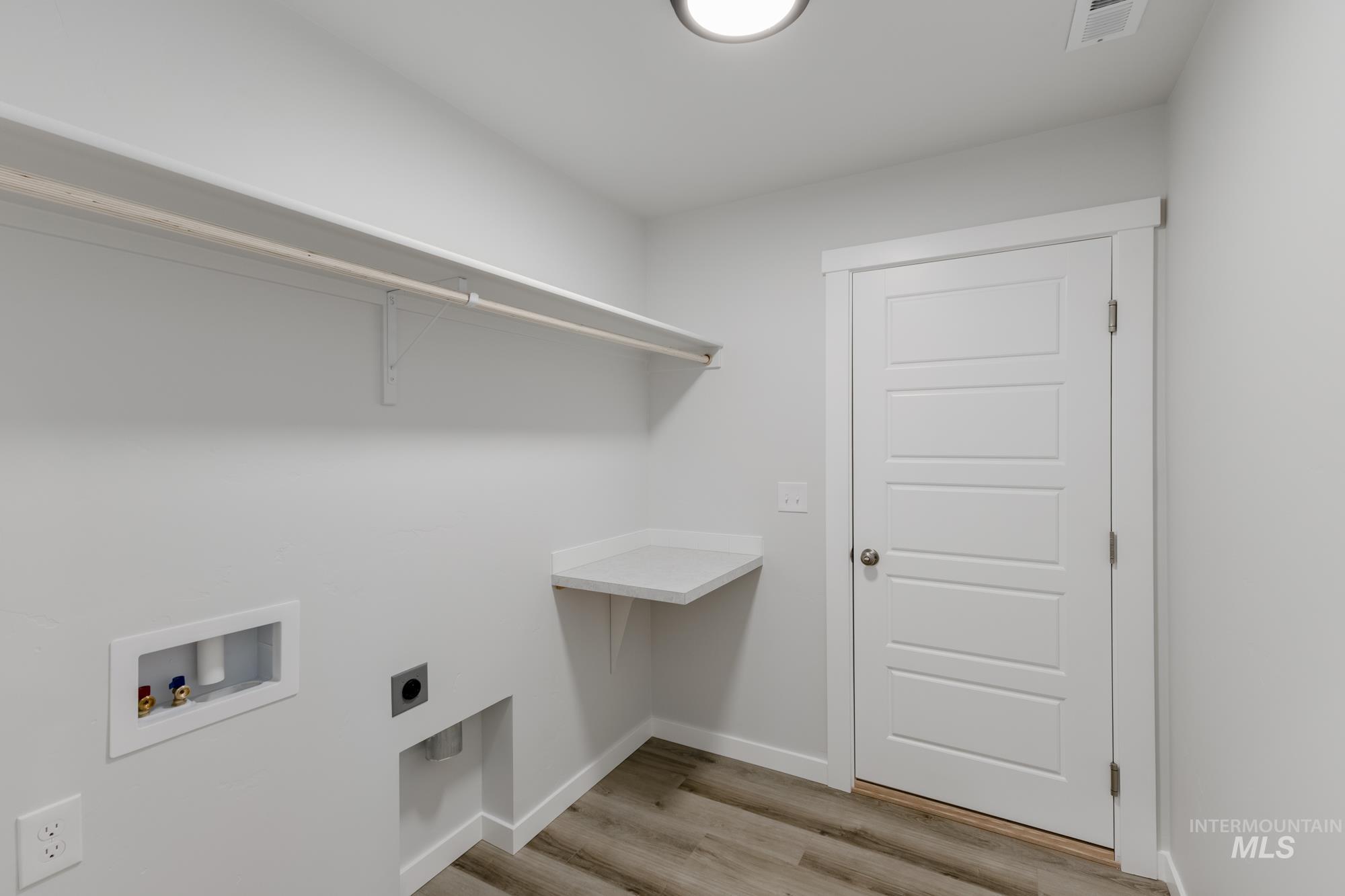 16697 Carlin Avenue Caldwell, ID 83607 - Photo 13 of 18 Washroom featuring light wood-type flooring, hookup for a washing machine, and electric dryer hookup