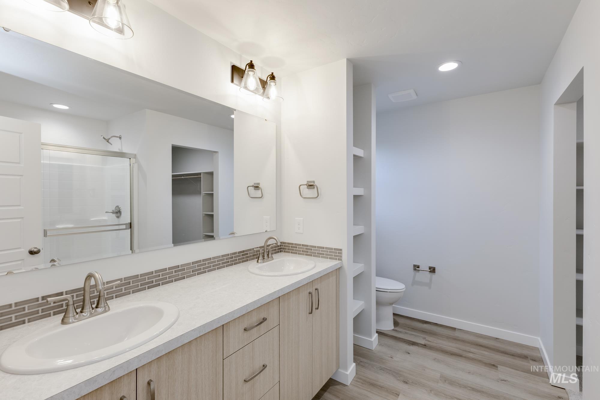16697 Carlin Avenue Caldwell, ID 83607 - Photo 17 of 18 Full bath featuring a walk in closet, a stall shower, double vanity, light wood-type flooring, and recessed lighting
