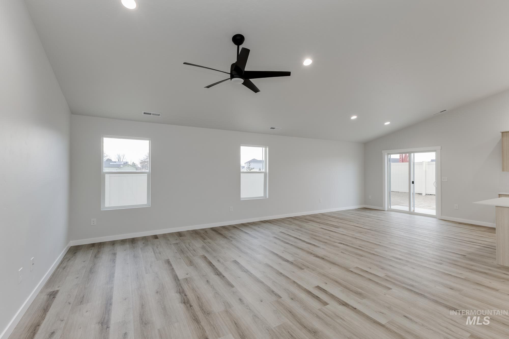 16697 Carlin Avenue Caldwell, ID 83607 - Photo 7 of 18 Unfurnished living room featuring recessed lighting, light wood-type flooring, plenty of natural light, lofted ceiling, and a ceiling fan