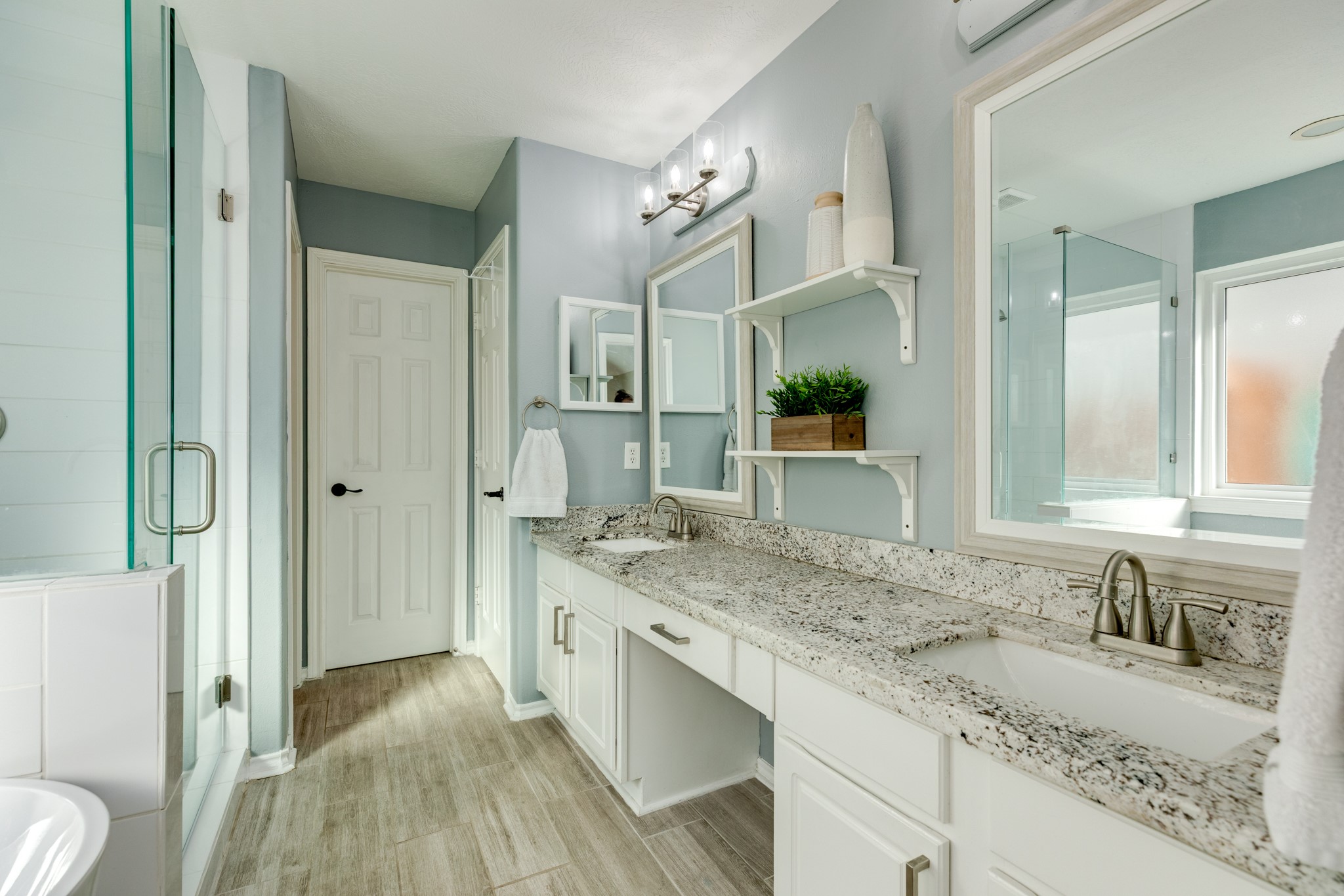 4113 Merlet Drive Pearland, TX 77584 - Photo 21 of 36 This view of the primary bath showcases the beautiful granite countertops, double vanities, two large mirrors, and the entrance to the walk-in closet.