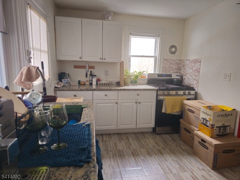 149 Broad Street Summit, NJ 07901 - Photo 11 of 12 a kitchen with a stove white cabinetry and wooden floor