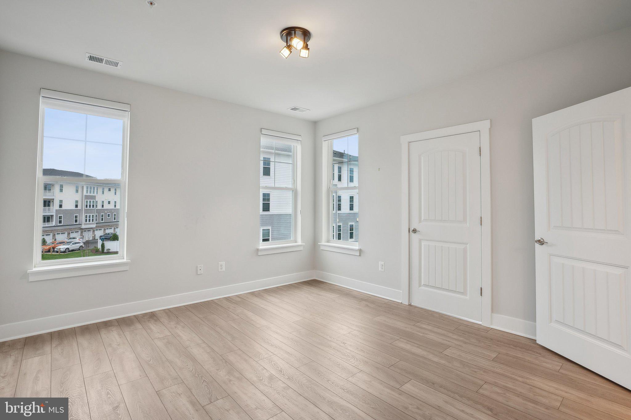 170 Harrier Way, Unit 34 Chester, MD 21619 - Photo 26 of 81 an empty room with wooden floor and windows