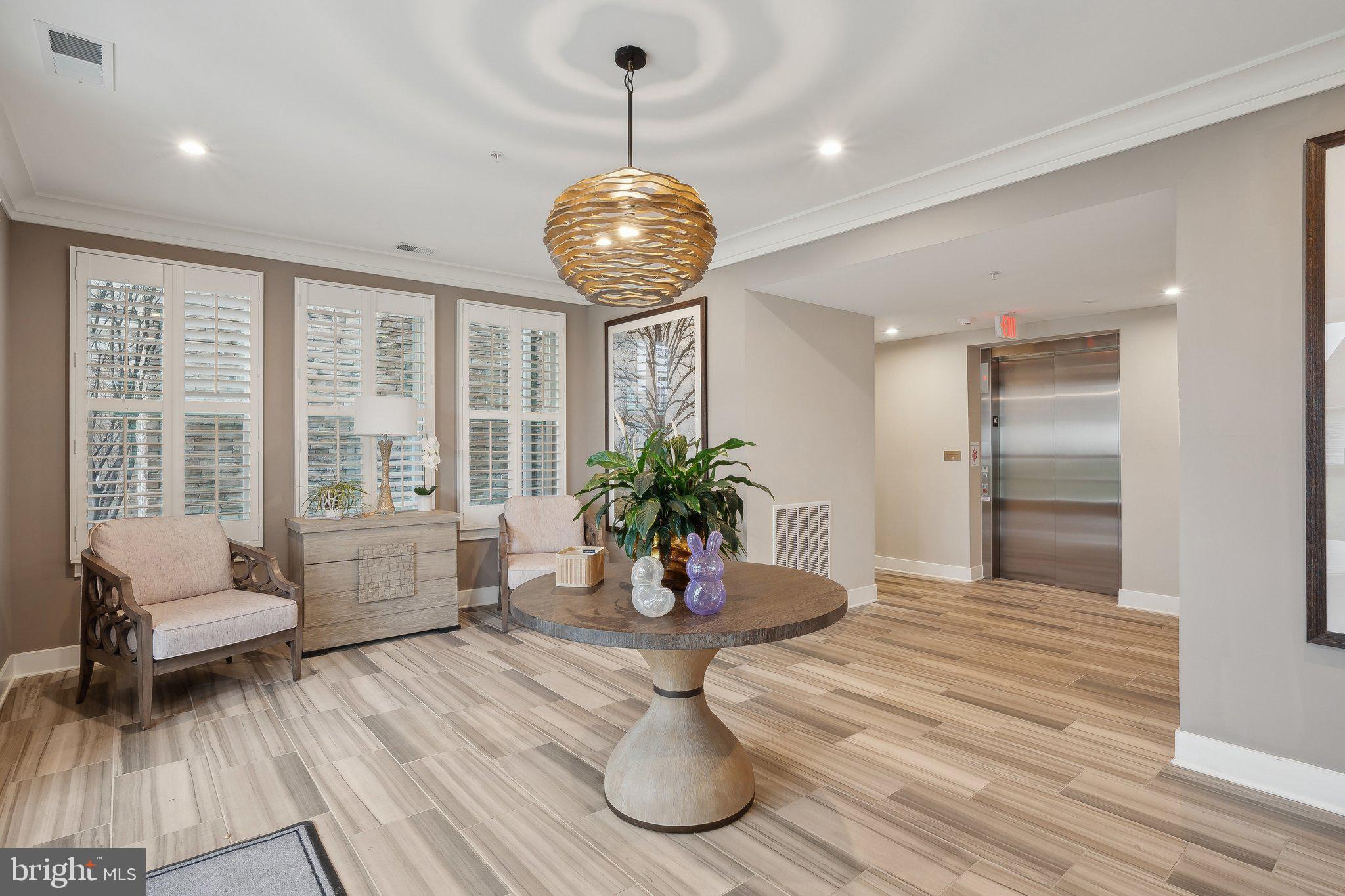 170 Harrier Way, Unit 34 Chester, MD 21619 - Photo 35 of 81 a dining room with wooden floor a chandelier a wooden table and chairs