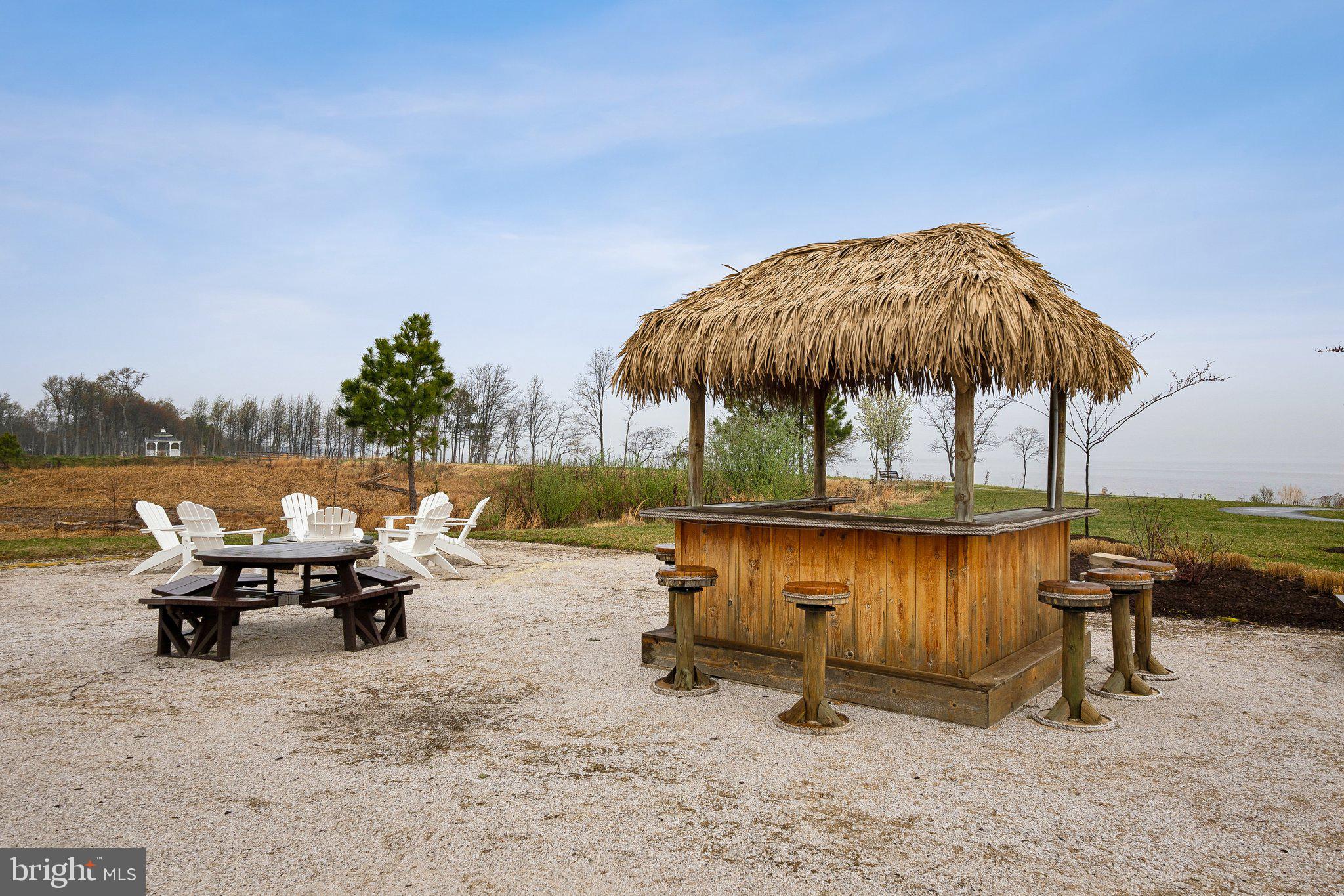 170 Harrier Way, Unit 34 Chester, MD 21619 - Photo 61 of 81 a view of a lake with tables and chairs under an umbrella