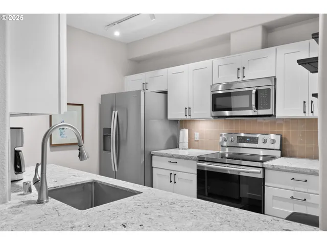 a kitchen with stainless steel appliances a stove a sink and a microwave