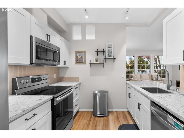 a kitchen with granite countertop a sink a stove and cabinets