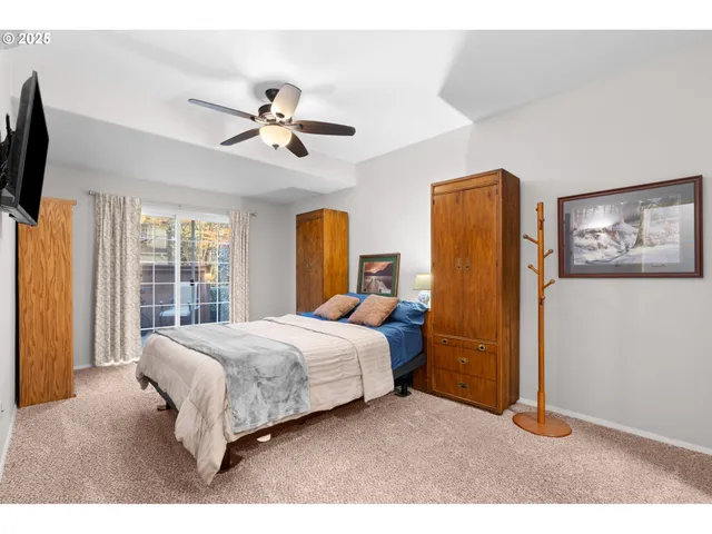 a bedroom with a bed flat screen tv and a window