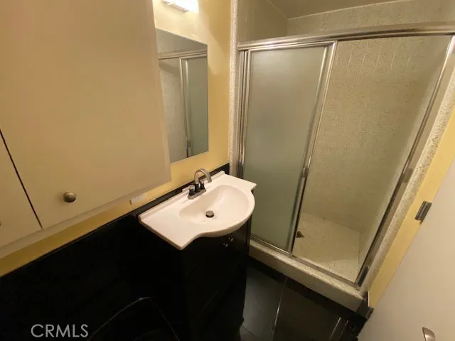 a bathroom with a sink a mirror and a shower