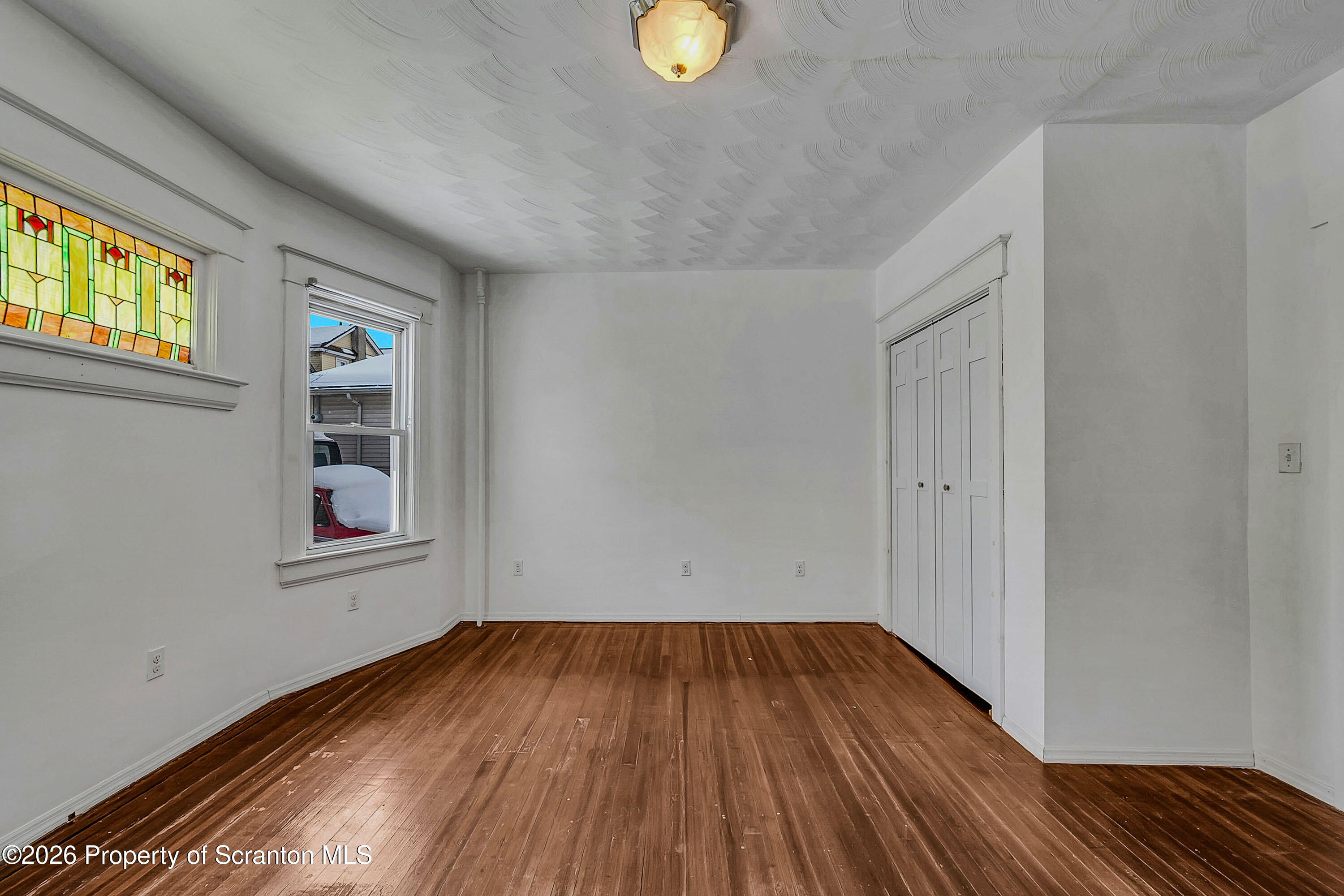 208 East Warren Street, Unit 1 Dunmore, PA 18512 - Photo 11 of 18 a view of an empty room with wooden floor and a window