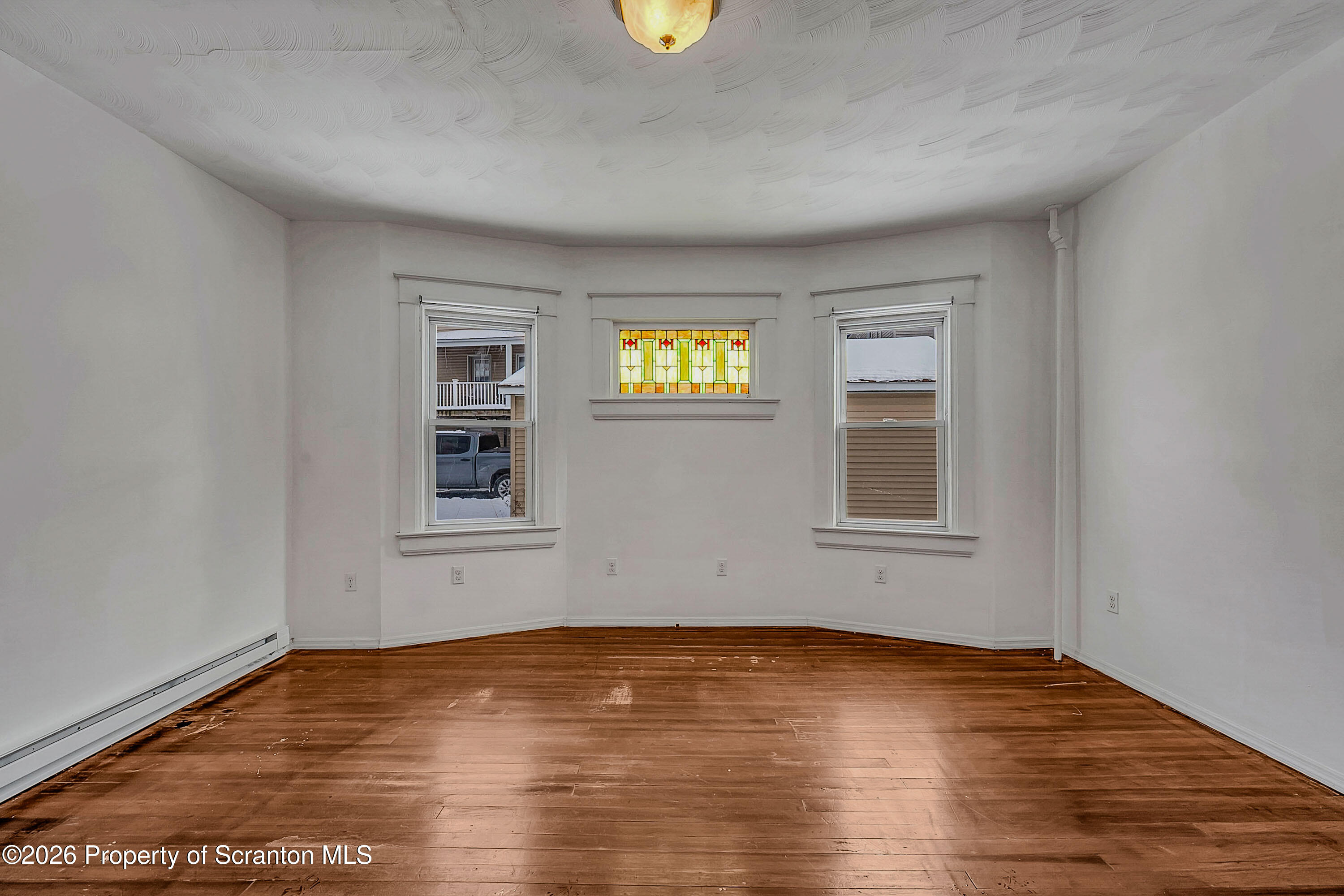 208 East Warren Street, Unit 1 Dunmore, PA 18512 - Photo 13 of 18 a view of an empty room with wooden floor and a window