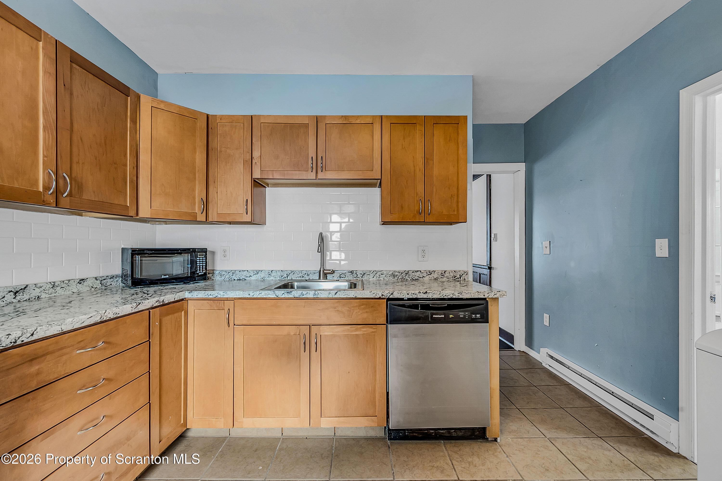 208 East Warren Street, Unit 1 Dunmore, PA 18512 - Photo 16 of 18 a kitchen with granite countertop a sink and white cabinets