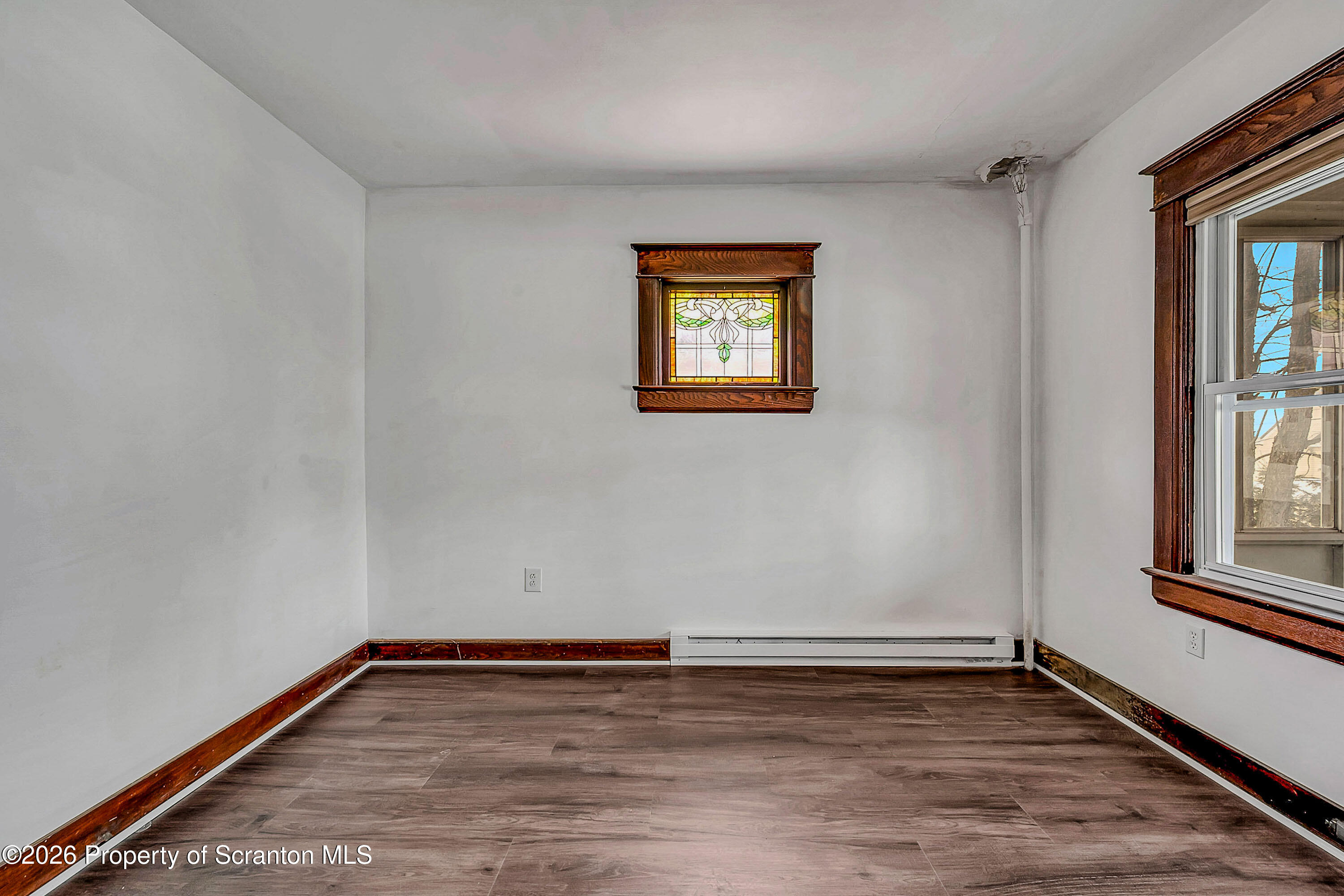 208 East Warren Street, Unit 1 Dunmore, PA 18512 - Photo 7 of 18 a view of an empty room with wooden floor and a window