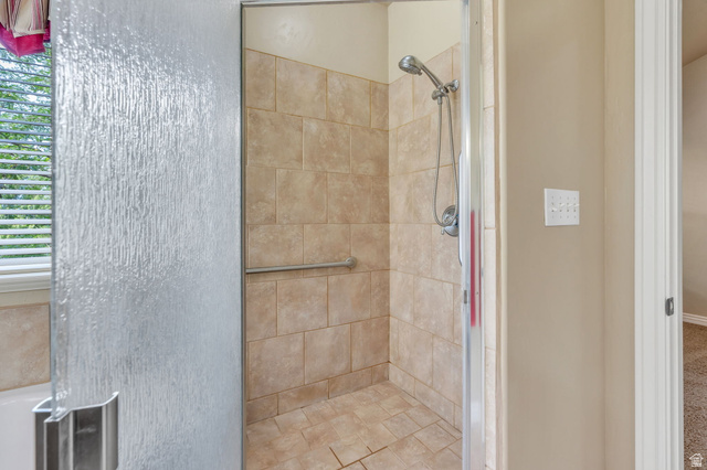 373 East Alexander Drive Elk Ridge, UT 84651 - Photo 21 of 69 Walk-in shower with full-height tile surround, integrated grab bar, and hand-held shower fixture