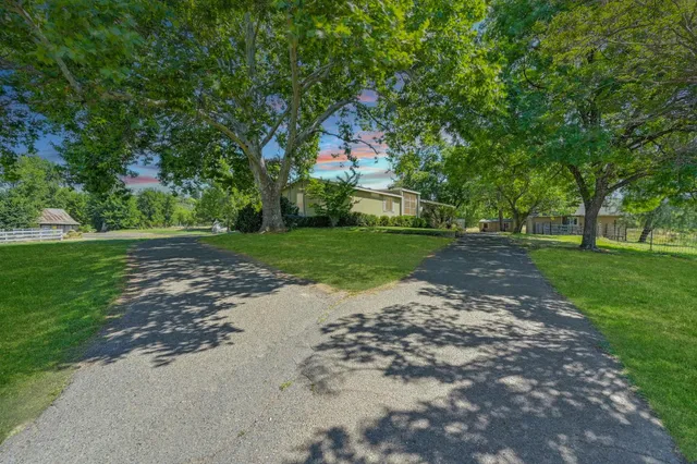 a kitchen with stainless steel appliances granite countertop a stove a sink and a refrigerator with wooden floors