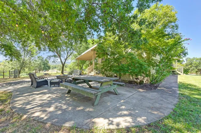 a backyard of a house with potted plants and large tree