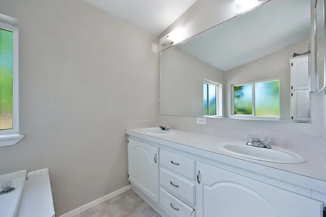 an aerial view of residential houses with outdoor space and trees