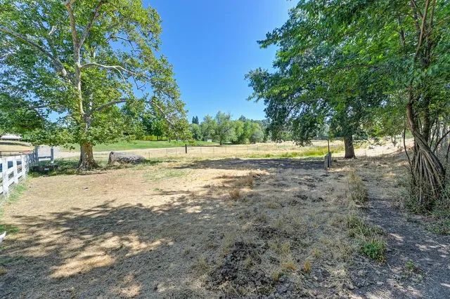 an aerial view of residential houses with outdoor space and trees