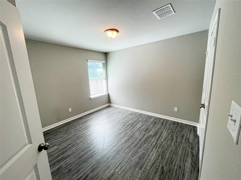 3920 South Fork Ranch Road Waco, TX 76705 - Photo 17 of 21 an empty room with wooden floor and windows