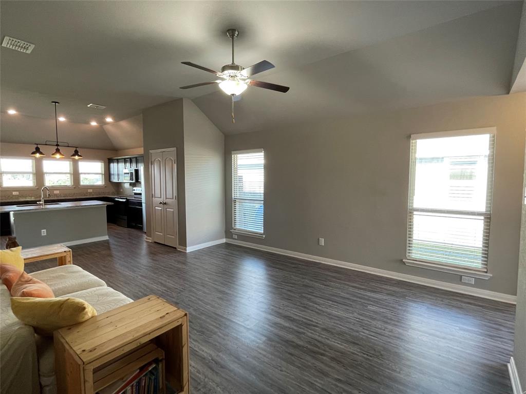 3920 South Fork Ranch Road Waco, TX 76705 - Photo 3 of 21 an open kitchen with wooden floor and chandelier