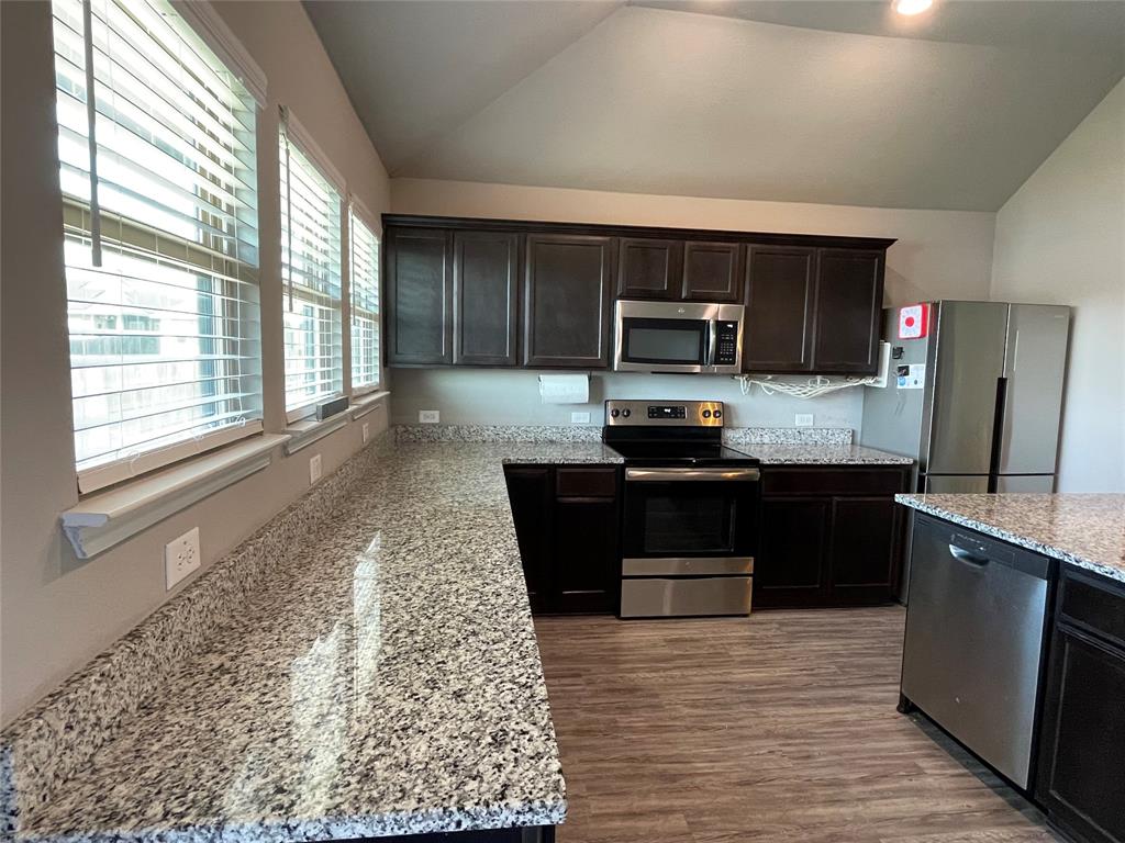 3920 South Fork Ranch Road Waco, TX 76705 - Photo 9 of 21 a kitchen with granite countertop a refrigerator and a stove top oven