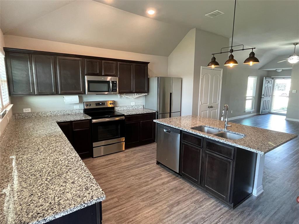 3920 South Fork Ranch Road Waco, TX 76705 - Photo 10 of 21 a kitchen with kitchen island granite countertop a sink counter and wooden cabinets