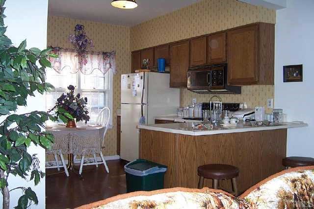 6151 Bushmills Street Raleigh, NC 27613 - Photo 2 of 10 a kitchen with sink a microwave and cabinets