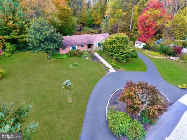 an aerial view of a house with a garden and swimming pool