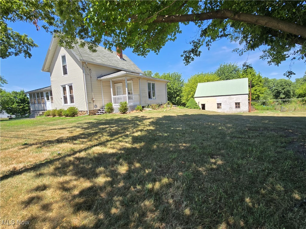 5555 Detroit Road Sheffield, OH 44054 - Photo 50 of 50 View of front of house featuring a chimney, covered porch, and a front yard