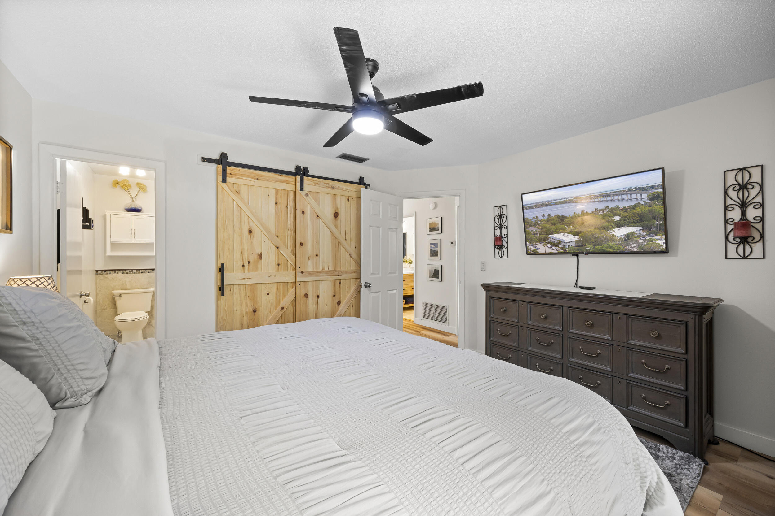 2929 Southeast Ocean Boulevard, Unit 10510 Stuart, FL 34996 - Photo 12 of 37 a bedroom with a large bed and a chandelier