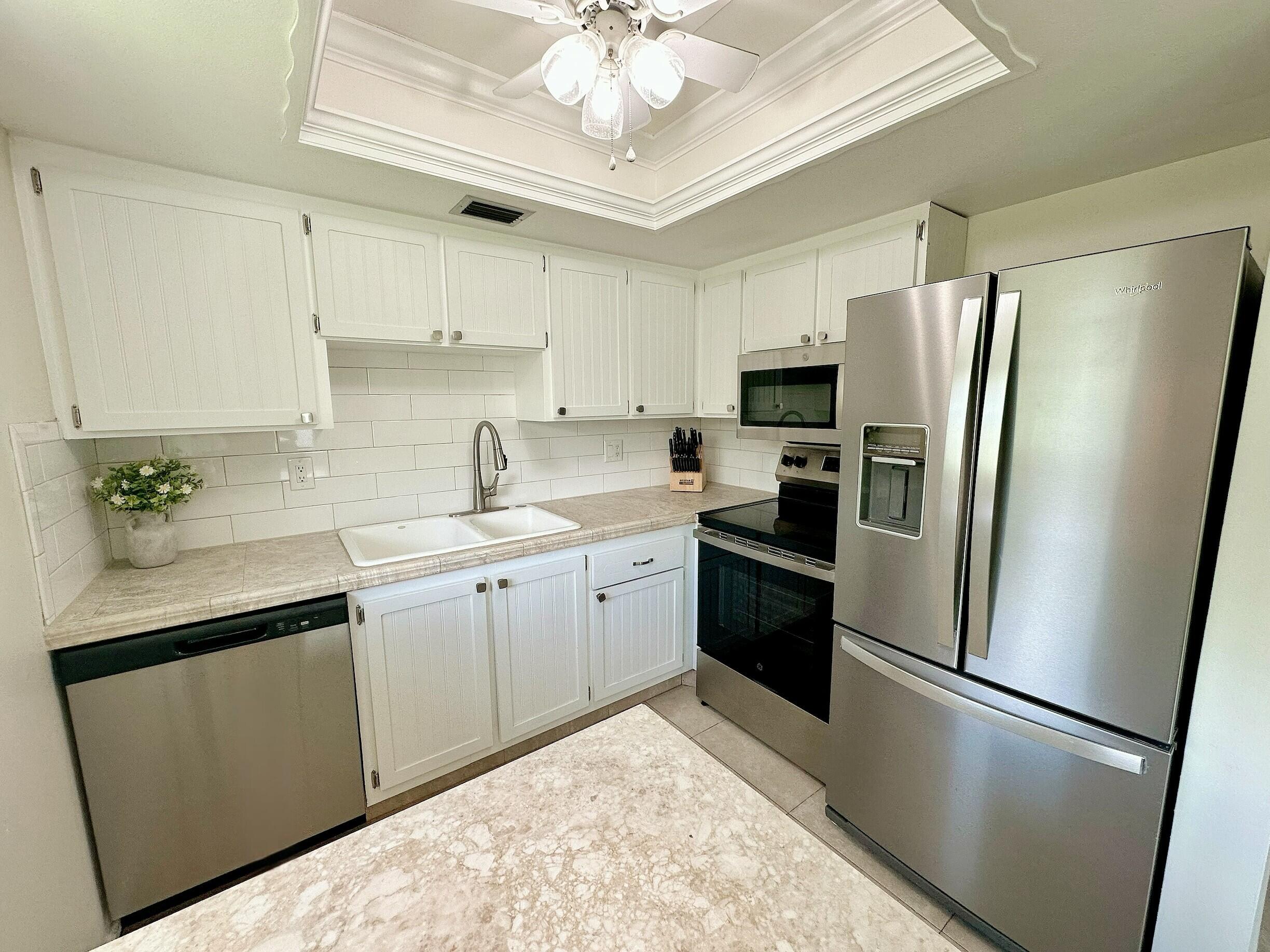 2929 Southeast Ocean Boulevard, Unit 10510 Stuart, FL 34996 - Photo 7 of 37 a kitchen with a refrigerator a sink a stove and cabinets