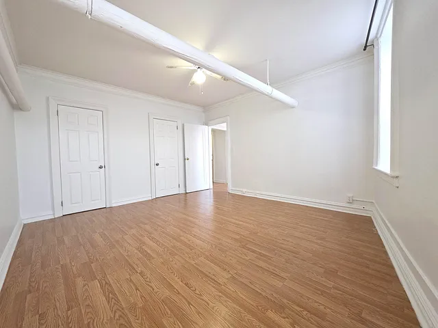 a view of an empty room with wooden floor