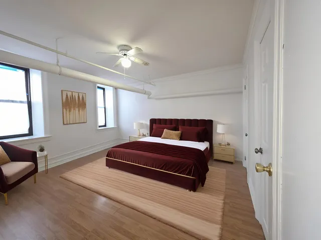 a bedroom with a large bed and a chandelier