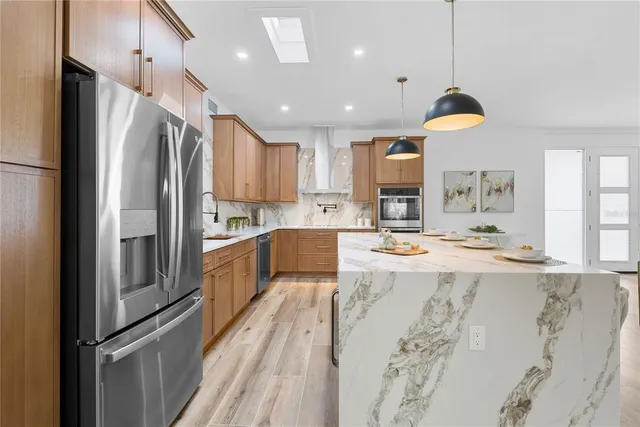 a kitchen with stainless steel appliances granite countertop a refrigerator and a stove top oven