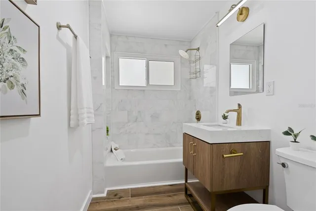 a bathroom with a bathtub sink vanity and mirror
