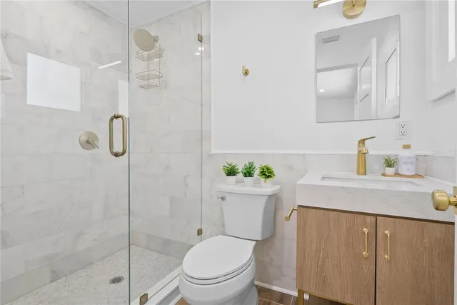 a bathroom with a sink a toilet and shower