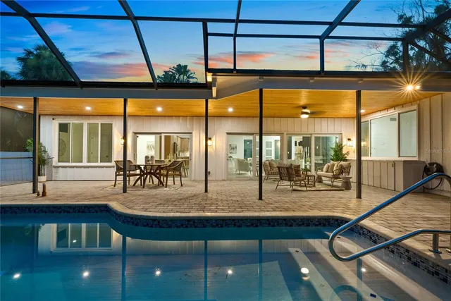 a room with lots of tables a large window and chairs